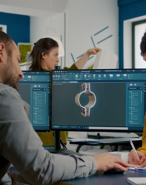 Equipo de trabajo de Sophia Consultores diseñando una pieza en software CAD con doble monitor en una oficina moderna.